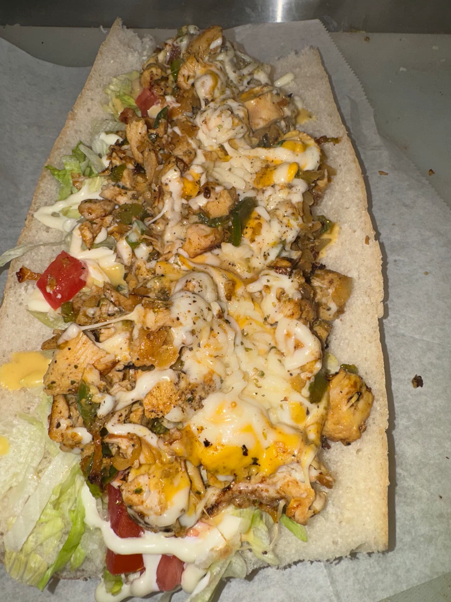 Grilled chicken sub loaded with cheese, peppers and lettuce