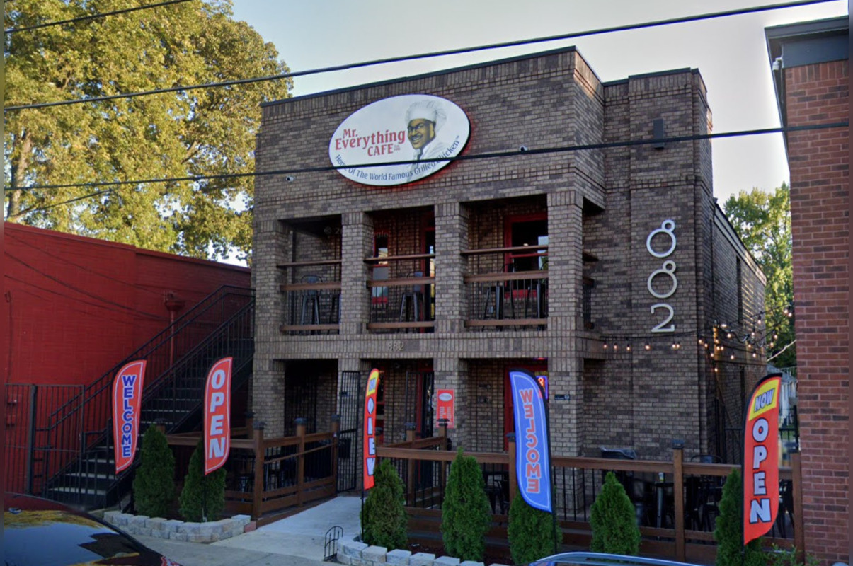 Mr Everything Cafe original location at 882 M.L.K. Jr. Dr. SW in Atlanta, brick building with the chef logo sign and open flags